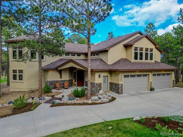 15947 Huckleberry Hts, Colorado Springs, CO 80908 - view of front of property featuring a garage, stucco siding, driveway, and stone siding