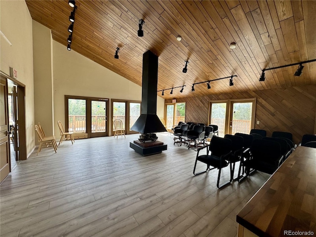 12166 Melody Dr Unit 202, Denver, CO 80234 - living room featuring rail lighting, a wood stove, wooden ceiling, wood finished floors, and high vaulted ceiling