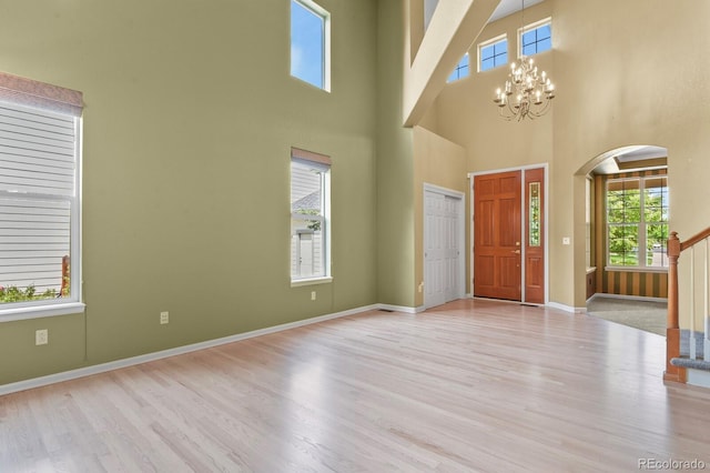 6533 S Ouray St, Aurora, CO 80016 - foyer with healthy amount of natural light, wood finished floors, a chandelier, a high ceiling, and stairway