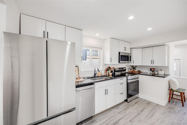 3249 W Alaska Pl, Denver, CO 80219 - kitchen with white cabinets, dark countertops, stainless steel appliances, and a sink