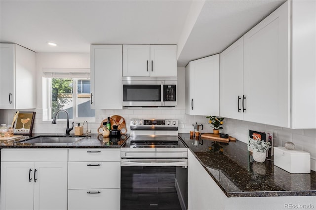 3249 W Alaska Pl, Denver, CO 80219 - kitchen with a sink, stainless steel appliances, dark stone counters, white cabinetry, and decorative backsplash