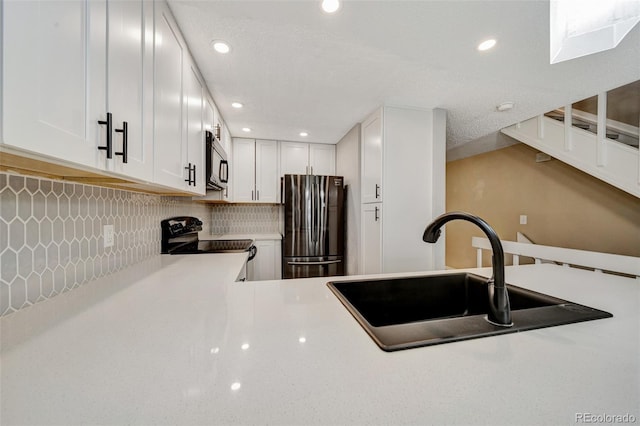 435 Dahlia St, Fort Morgan, CO 80701 - kitchen with freestanding refrigerator, range with electric stovetop, light countertops, backsplash, and white cabinets