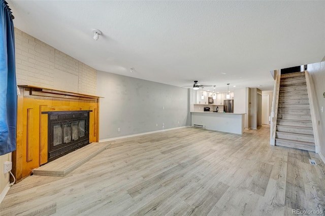 435 Dahlia St, Fort Morgan, CO 80701 - unfurnished living room with a fireplace, light wood finished floors, stairway, and a ceiling fan