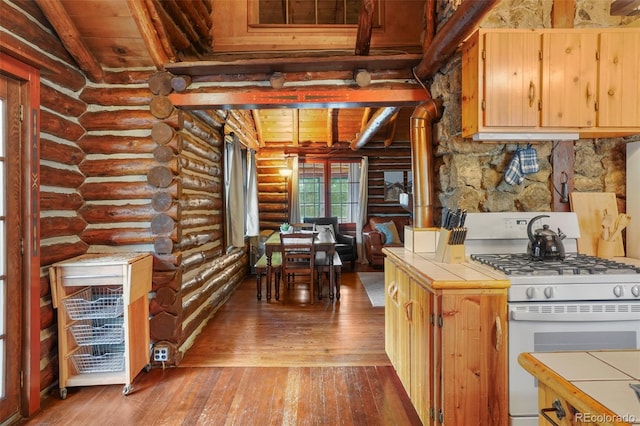 kitchen featuring tile countertops, white range with gas cooktop, wood-type flooring, and log walls