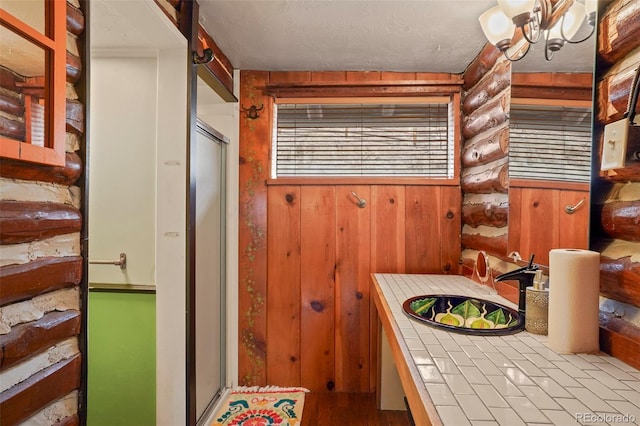 bathroom featuring wooden walls and sink