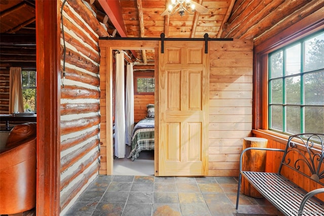 interior space featuring a barn door, wood ceiling, and lofted ceiling