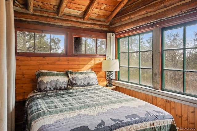 bedroom featuring wood walls, multiple windows, wood ceiling, and lofted ceiling