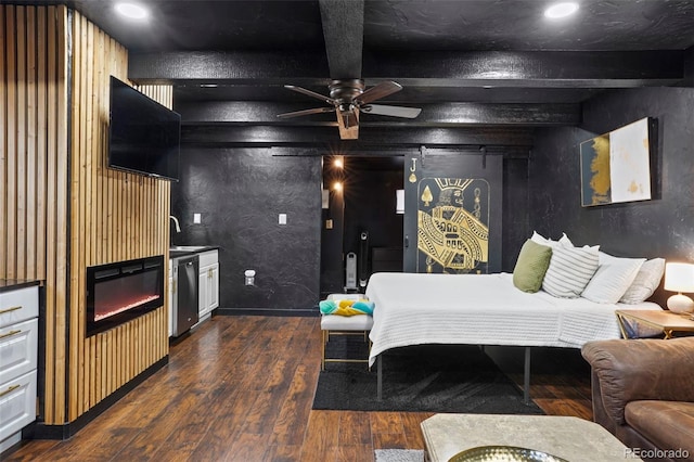 bedroom with dark wood-type flooring, wooden walls, sink, beam ceiling, and a fireplace