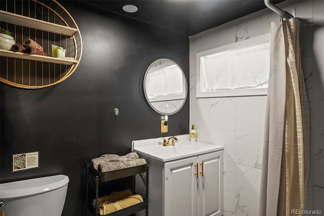 bathroom featuring curtained shower, vanity, and toilet