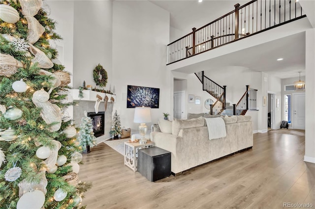 living room with a towering ceiling and light hardwood / wood-style floors