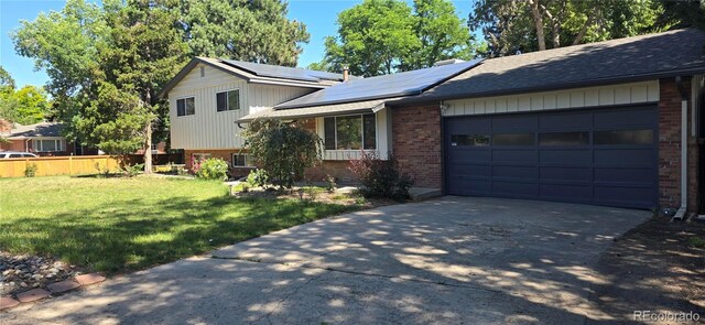 12475 W 38th Ave, Wheat Ridge, CO 80033 - tri-level home featuring brick siding, driveway, a garage, roof mounted solar panels, and a shingled roof
