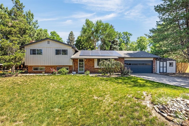 12475 W 38th Ave, Wheat Ridge, CO 80033 - tri-level home with concrete driveway, an attached garage, brick siding, and roof mounted solar panels