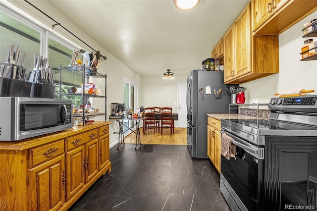 12475 W 38th Ave, Wheat Ridge, CO 80033 - kitchen featuring stainless steel appliances, brown cabinetry, and light countertops