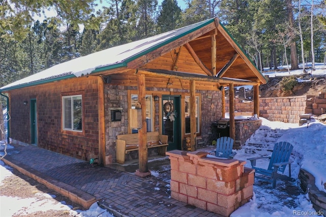 view of front of house featuring a patio area and metal roof