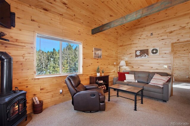 526 Wakanda Trl, Woodland Park, CO 80863 - carpeted living area with wood ceiling, a wood stove, wood walls, and vaulted ceiling with beams