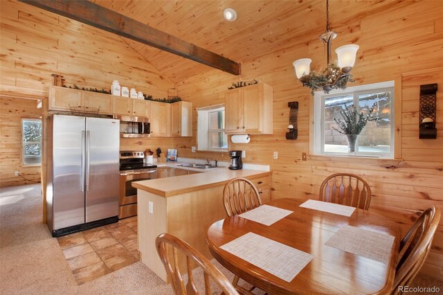 526 Wakanda Trl, Woodland Park, CO 80863 - kitchen featuring a peninsula, stainless steel appliances, light brown cabinets, and wood walls