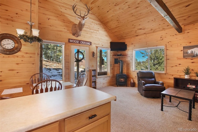 526 Wakanda Trl, Woodland Park, CO 80863 - interior space with a wood stove, high vaulted ceiling, wooden ceiling, wooden walls, and carpet flooring