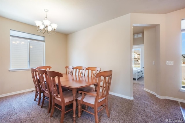 carpeted dining space with an inviting chandelier and baseboards