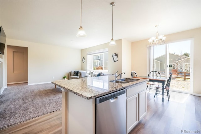 kitchen featuring a sink, stainless steel dishwasher, light wood finished floors, and a wealth of natural light