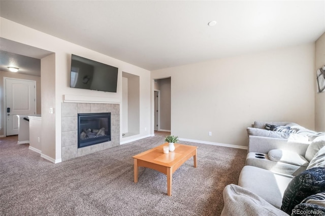 carpeted living area featuring a fireplace and baseboards