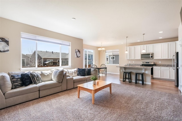 living room featuring a chandelier, recessed lighting, and light wood-type flooring