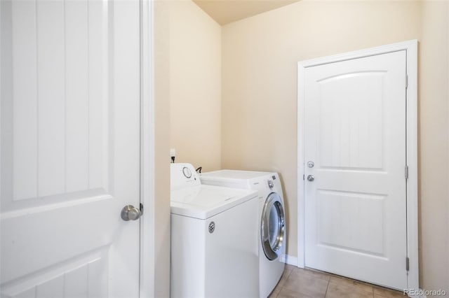 laundry area featuring washing machine and clothes dryer, light tile patterned flooring, and laundry area