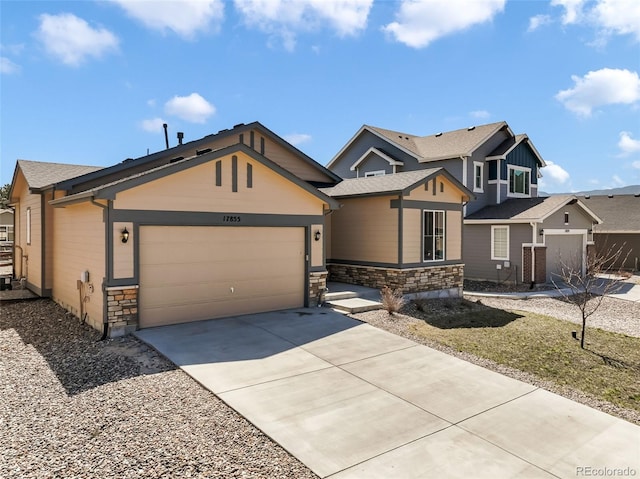 craftsman inspired home featuring a garage, driveway, and stone siding