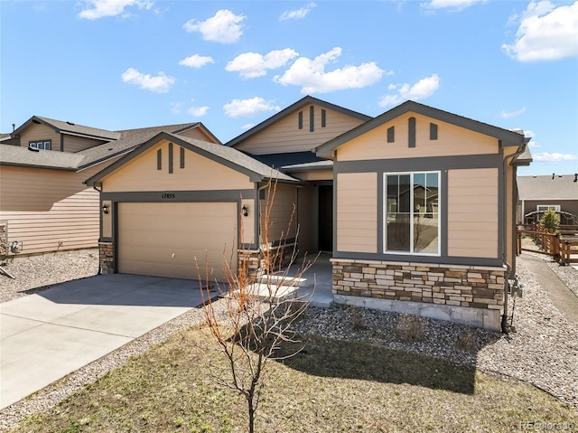 view of front facade with concrete driveway, a garage, and stone siding