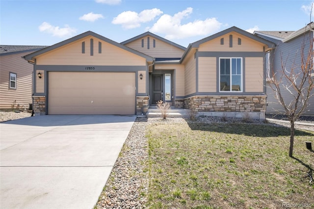 view of front of property featuring a garage, a front yard, driveway, and stone siding