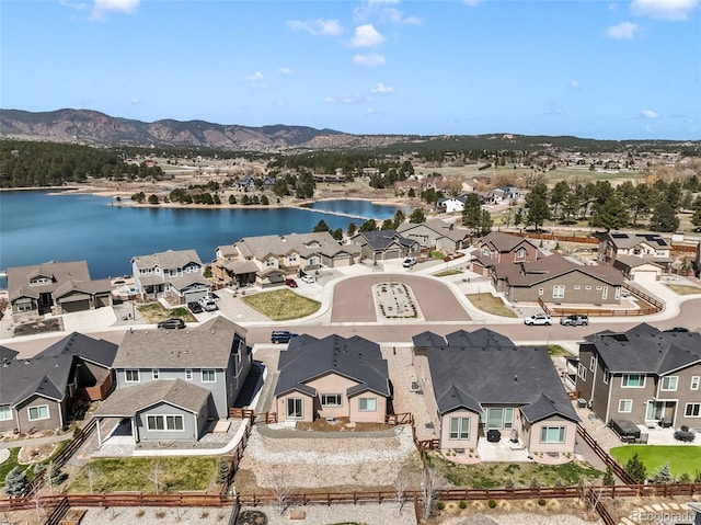 drone / aerial view featuring a water and mountain view and a residential view