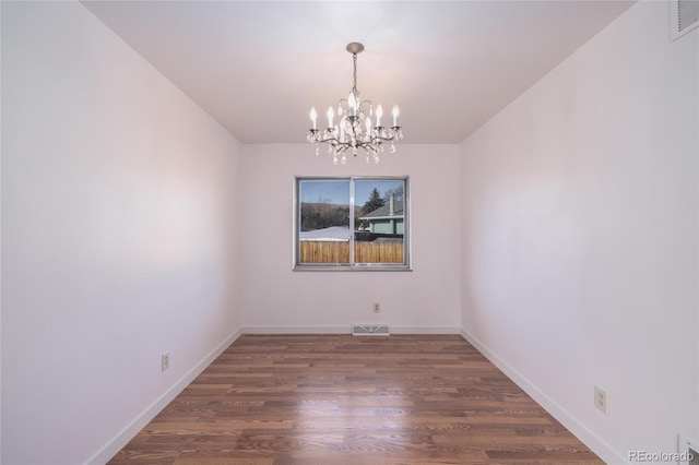 unfurnished room featuring dark wood-type flooring and a chandelier