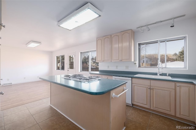 kitchen with sink, a wealth of natural light, a center island, and stainless steel gas cooktop