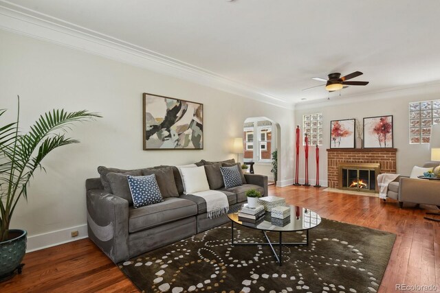 916 Adams St, Denver, CO 80206 - living room with arched walkways, ornamental molding, hardwood / wood-style floors, baseboards, and ceiling fan