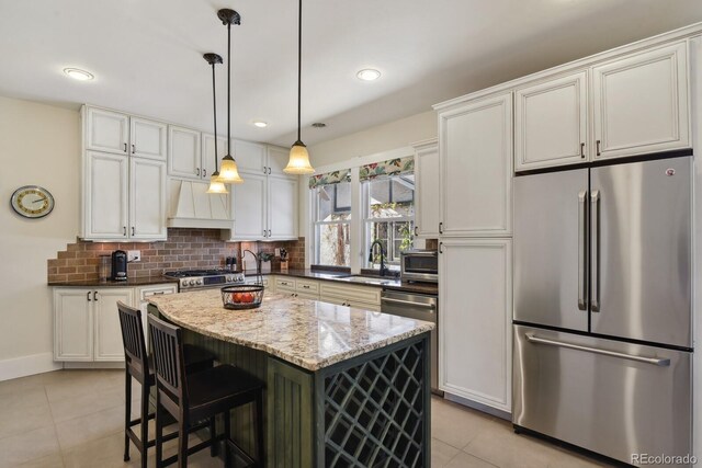 916 Adams St, Denver, CO 80206 - kitchen featuring freestanding refrigerator, custom range hood, a sink, light tile patterned floors, and white cabinets