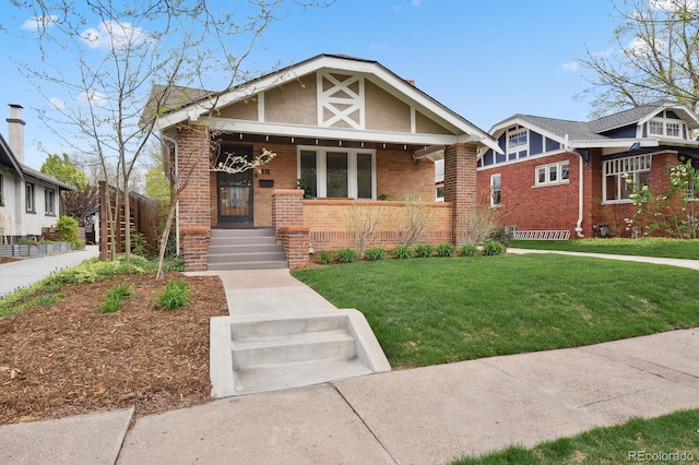 916 Adams St, Denver, CO 80206 - view of front of property with brick siding, a front lawn, and covered porch