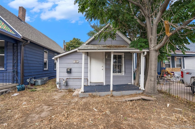 view of front facade featuring covered porch and fence