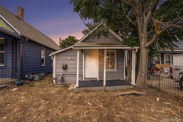 view of front of property with covered porch and fence