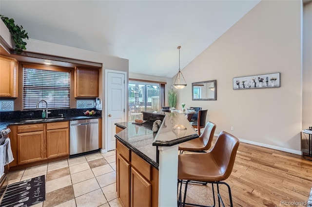 2417 S Racine Way, Aurora, CO 80014 - kitchen featuring stainless steel appliances, a breakfast bar, tasteful backsplash, dark stone counters, and high vaulted ceiling
