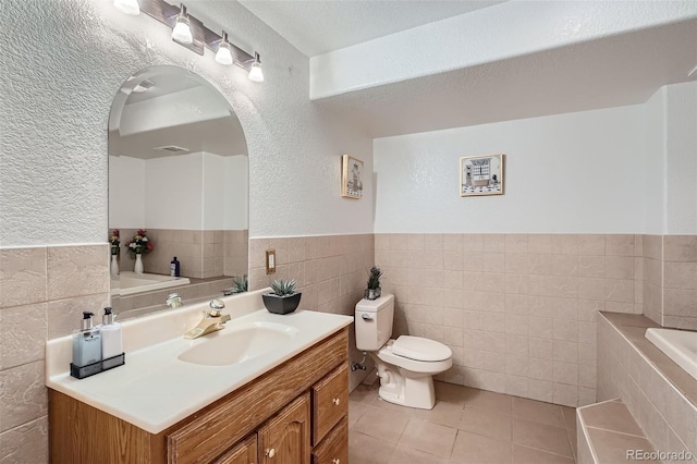 2417 S Racine Way, Aurora, CO 80014 - bathroom with tile walls, a garden tub, tile patterned flooring, vanity, and a wainscoted wall