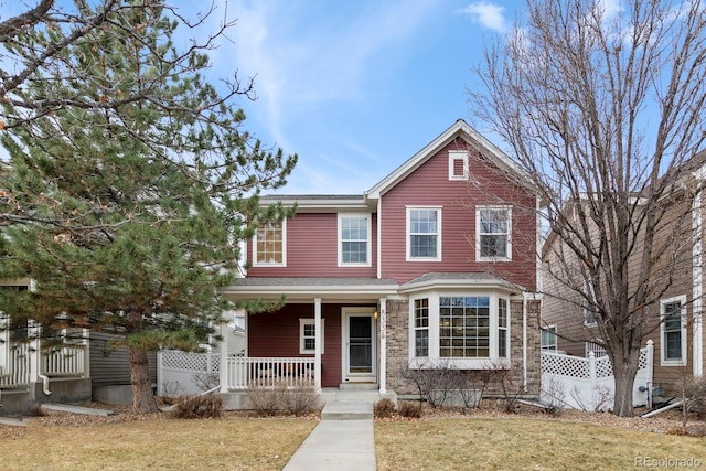 traditional home featuring a front lawn and a porch