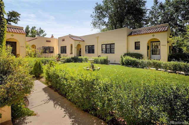 mediterranean / spanish-style house featuring a front lawn