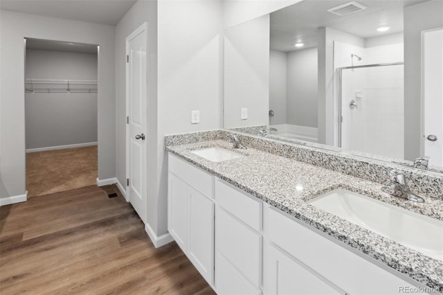 bathroom with vanity, wood-type flooring, and a shower with door