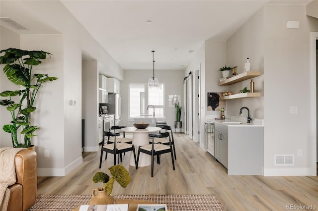 8280 E 36th Ave Unit 26, Denver, CO 80238 - dining room with light wood-type flooring, baseboards, and a chandelier