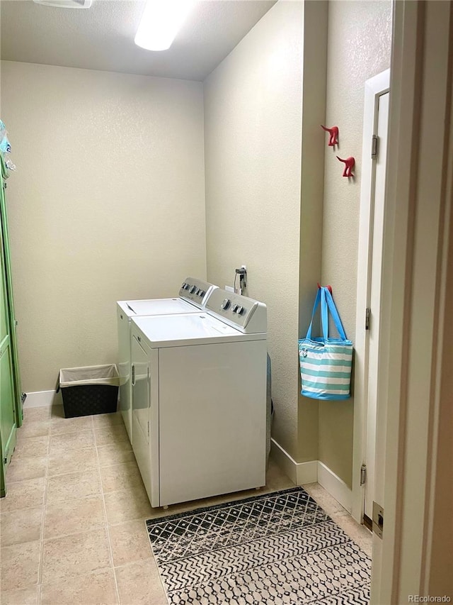 laundry area with laundry area, baseboards, separate washer and dryer, and light tile patterned floors