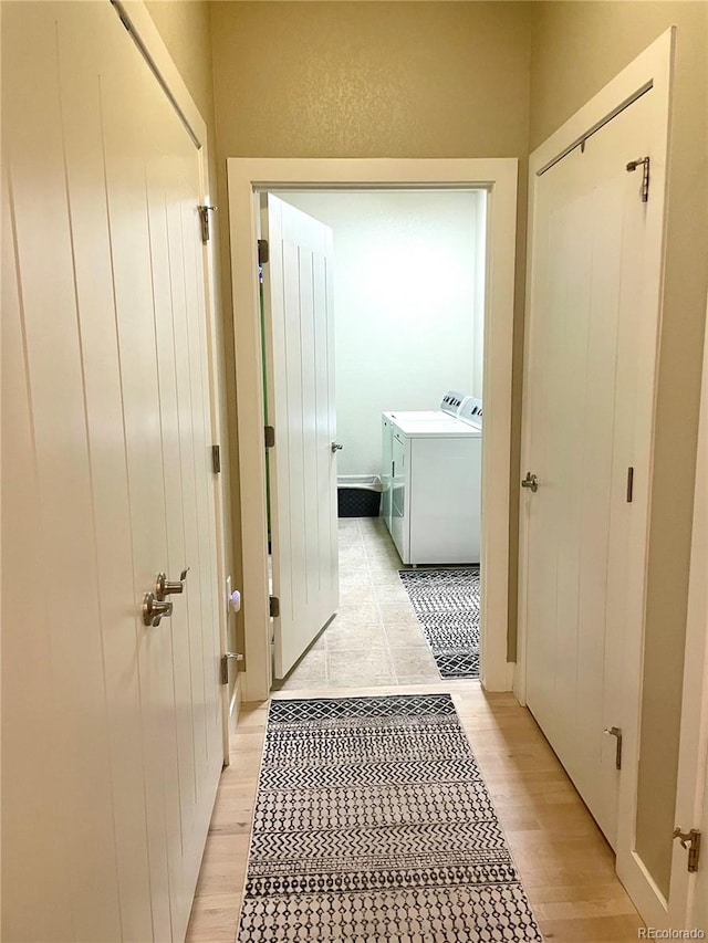 corridor featuring light wood-style floors and washer and dryer
