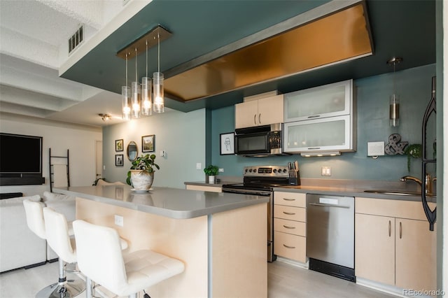 675 S University Blvd Unit 106, Denver, CO 80209 - kitchen with stainless steel appliances, open floor plan, a sink, a kitchen breakfast bar, and a kitchen island