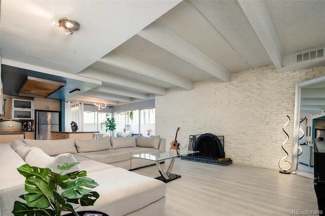 675 S University Blvd Unit 106, Denver, CO 80209 - living room with wood finished floors, beam ceiling, a textured ceiling, and a large fireplace