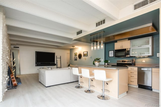 675 S University Blvd Unit 106, Denver, CO 80209 - kitchen featuring appliances with stainless steel finishes, light wood-style flooring, beam ceiling, a kitchen breakfast bar, and pendant lighting