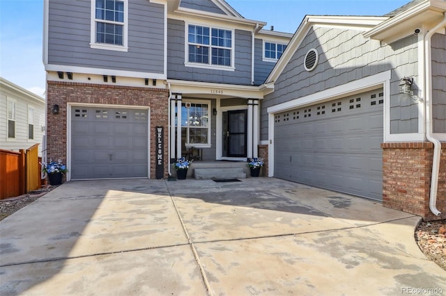 view of front of home with a garage, concrete driveway, and brick siding