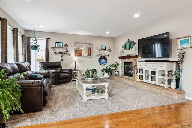 living area with recessed lighting, a fireplace, and wood finished floors